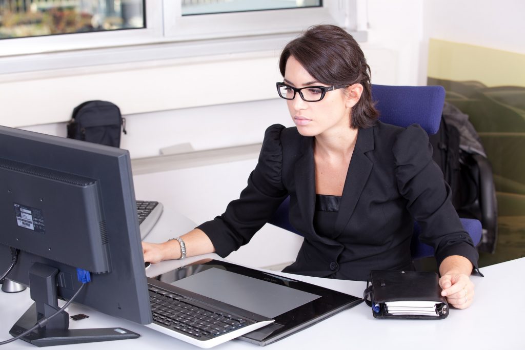 An assistant working at a computer in a bright office